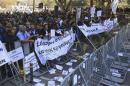 Demonstrators hold signs and banners outside Cyprus's parliament as they protest plans by the government to sell off state-owned enterprises, in Nicosia