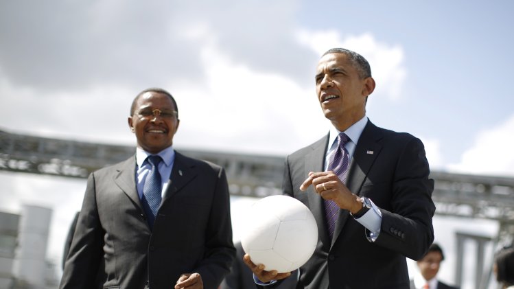 U.S. President Obama holds a soccer ball alongside Tanzania's President Kikwete during a demonstration at the Ubungo Power Plant in Dar es Salaam