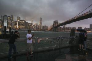 Tourists stand underneath the Brooklyn Bridge to photograph&nbsp;&hellip;