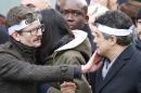 Charlie Hebdo newspaper staff, with editorialist Patrick Pelloux, right, cartoonist Renald Luzier, known as Luz, left, react during a march in Paris, France, Sunday, Jan. 11, 2015. Thousands of people began filling France's iconic Republique plaza, and world leaders converged on Paris in a rally of defiance and sorrow on Sunday to honor the 17 victims of three days of bloodshed that left France on alert for more violence. (AP Photo/Michel Euler)