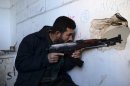 Un rebelde sirio toma posición para disparar en el barrio de Bustan al-Basha, este martes en Alepo (norte de Siria)
