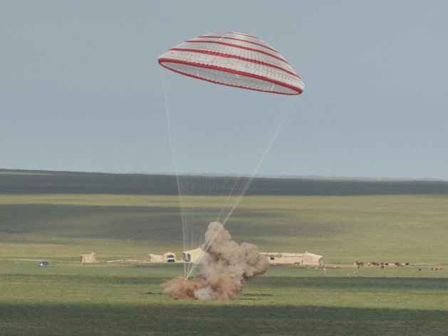 In this photo released by China's Xinhua News Agency, the re-entry capsule of China's Shenzhou 10 spacecraft lands in Siziwang Banner, north China's Inner Mongolia Autonomous Region on Wednesday, June 26, 2013. The space capsule with three astronauts has safely landed on grasslands in northern China after a 15-day trip to the country's prototype space station. (AP Photo/Xinhua,Ren Junchuan) NO SALES