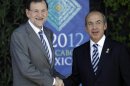 Spain's Prime Minister Mariano Rajoy, left, greets Mexico's President Felipe Calderon as they pose for pictures during the opening ceremony of the G20 Summit in Los Cabos, Mexico, Monday, June 18, 2012. (AP Photo/Eduardo Verdugo)
