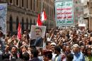 People hold a poster of Yemen's former president Ali Abdullah Saleh as they demonstrate outside a parliament a session in Sanaa, Yemen