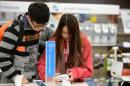 Louis Liu, left, and Chian Chow look at a Samsung Galaxy camera photo at a Best Buy late in the evening on Thanksgiving Day, Thursday, Nov. 28, 2013, in Dunwoody, Ga. Instead of waiting for Black Friday, which is typically the year's biggest shopping day, more than a dozen major retailers opened on Thanksgiving this year. (AP Photo/David Tulis)