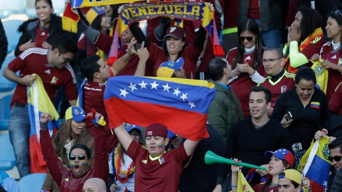 Fans of Venezuela celebrate at the end of the match between Venezuela and Colombia during a Copa America Group C soccer match at El Teniente stadium in Rancagua, Chile, Sunday, June 14, 2015. Venezuela won the game 1-0.(AP Photo/Ricardo Mazalan)