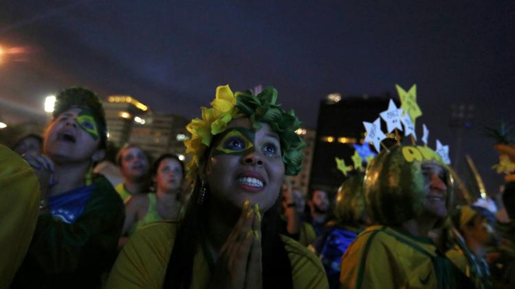 Brazilian fans celebrate a goal as they watch the match between Brazil and Cameroon which was broadcast on a large screen at Copacabana beach in Rio de Janeiro