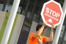 Un hombre con un cartel en el que se lee 'Stop desahucios' frente a la sede de Bankia en Valencia este viernes