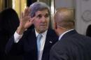 U.S. Secretary of State Kerry gestures as he arrives at a hotel in Vienna