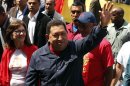 Venezuela's President and presidential candidate Hugo Chavez waves as he arrives at a school to cast his vote during the presidential election in Caracas