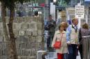 Visitors watch a replica of the Berlin Wall at an exhibition about the fall of the Wall in Berlin