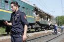 An Interior Ministry security force member stands guard near a passenger train damaged in a collision with a freight train in Moscow region