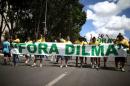Protesters hold a banner reading "Dilma out" in Brasilia