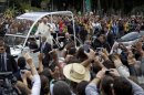 Pope Francis greets people from his popemobile in the Gloria neighborhood on his way to the archbishops's palace in Rio de Janeiro, Brazil, Friday, July 26, 2013. At the archbishops's palace Francis will hold a series of meetings and public noon prayer. (AP Photo/Felipe Dana)