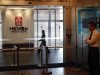Security guard stands at entrance as office worker walks inside the Hong Kong Mercantile Exchange in Hong Kong