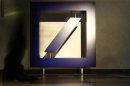 A visitor walks past the bank's logo prior to Deutsche Bank's annual news conference in Frankfurt