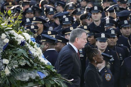 New York Mayor de Blasio and wife Chirlane walk past a sea of policemen while arriving for the funeral services of NYPD officer Ramos in the Queens...