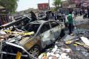 Iraqi men clear the debris at the scene of a car bomb in the Sadr City district in Baghdad, on August 1, 2014