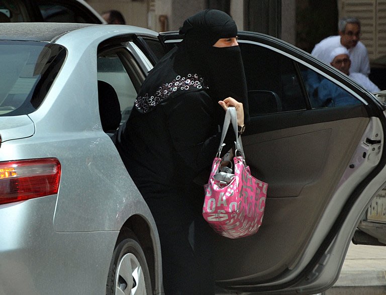 A Saudi woman gets out of a car after being given a ride by her driver in Riyadh, on May 26, 2011