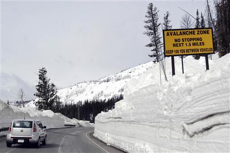 A car travels the newly plowed east entrance road over Sylvan Pass in Yellowstone National Park shortly after the park opened in this photo taken in May 2011. REUTERS/Ruffin Prevost