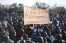 Miners sit together during a strike calling for increased wages at the platinum mine Lonmin