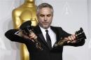 Alfonso Cuaron poses with the awards for best director and best film editing for "Gravity" at the 86th Academy Awards in Hollywood