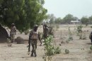 Soldiers walk through Hausari village during a military patrol near Maiduguri