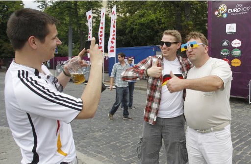 German soccer fans take a snapshot picture with a Ukrainian supporter in central Lviv