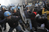 <p>               Students clash with police during a demonstration in Milan, Italy, Thursday, Nov. 17, 2011. University students are protesting in Milan and Rome against budget cuts and a lack of jobs, hours before new Italian Premier Mario Monti reveals his anti-crisis strategy in Parliament. Across Italy, transport unions called all-day walkouts or strikes of several hours Thursday to demand better work contracts. Scuffles among students were reported at the start of the demonstration in Milan, where they hoped to march to Bocconi University, which trains Italy's business elite. Monti, an economist, is Bocconi's president and is scheduled to speak in the afternoon ahead of a confidence vote on the government he formed on Wednesday. (AP Photo/Luca Bruno)