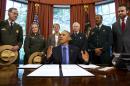 FILE - In this July 10, 2015, file photo, President Barack Obama, center, talks about the designation of three new national monuments; Berryessa Snow Mountain in California, Waco Mammoth in Texas, and the Basin and Range in Nevada, in the Oval Office of the White House in Washington. Behind him from left are Victor Knox, associate director of park planning, facilities and lands of the National Park Service; April Slayton, chief of public affairs and chief spokesperson of the National Park Service; Secretary of the Interior Sally Jewell; U.S. Forest Service Chief Tom Tidwell; Randy Moore, Forest Service; and Bureau of Land Management director Neil Kornze. The race is on to win Obama's attention as he puts some final touches on his environmental legacy. Conservation groups, American Indian tribes and lawmakers are pushing him to preserve millions of acres as national monuments. That designation often prevents new drilling and mining on public lands, or the construction of new roads and utility lines. (AP Photo/Jacquelyn Martin, File)