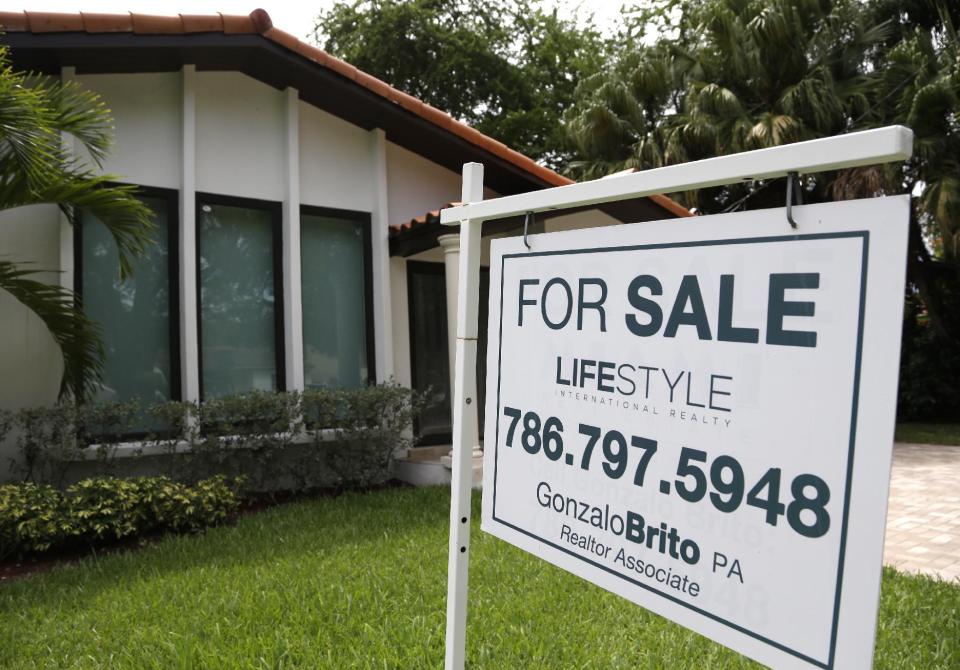 In this Saturday, Aug. 15, 2015 photo, a for sale sign is placed in front of a home in Miami.  A key housing index shows that U.S. home prices rose...