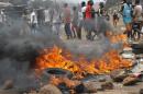 Tyres burn during clash between anti- riot policemen and Guinean opposition supporters on April 13, 2015 in Conakry