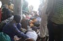 Injured people are comforted at the site after a bombing attack of an internally displaced persons camp in Rann