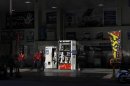 Workers stand to wait for customers at a gas station in Tokyo