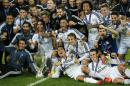 Real Madrid players pose with the trophy after winning the UEFA Super Cup soccer match between Real Madrid and Sevilla in Cardiff City Stadium, in Cardiff, Wales, Tuesday, Aug. 12, 2014. (AP Photo/Alastair Grant)