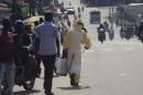 A health worker with disinfectant spray walks down a street outside the government hospital in Kenema