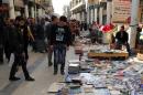 In this Friday, Jan. 23, 2015 photo, Iraqis look at books on al-Mutanabi Street, home to the city's book market in central Baghdad. One afternoon this month, Islamic State militants arrived at the Central Library of the northern city of Mosul in a non-combat mission. They broke the locks that kept the two-story building closed since the extremists overran the city in mid last year, loading some 2,000 books included children stories, poetry, philosophy, sports, health and cultural and scientific publications into six pickup trucks and leaving behind only the Islamic religious ones. (AP Photo/Karim Kadim)
