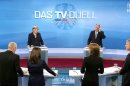 Photo provided by German broadcaster WDR shows German Chancellor Angela Merkel, background left, of the Christian Democrats and her Social Democratic challenger Peer Steinbrueck, background right, with journalists, from left, Stefan Raab, Anne Will, Maybrit Illner und Peter Kloeppel during the only live televised debate ahead of the national elections in Berlin, Sunday, Sept. 1, 2013. Germany is facing general elections on Sept. 22, 2013. (AP Photo/WDR)