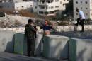 An Israeli border guard inspects a Palestinian man at a newly erected checkpoint at the exit of the east Jerusalem neighborhood of Issawiya on October 19, 2015