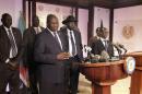 Sudan First Vice President Riek Machar (L), flanked by South Sudan President Salva Kiir (C) and other government officials, addresses a news conference at the Presidential State House in Juba