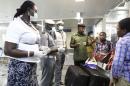 Nigerian custom officers wearing face masks and gloves screen passengers arriving at Nnamdi Azikiwe International Airport in Abuja