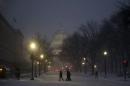 People walk in the falling snow near the U.S. Capitol in Washington