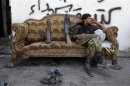 A Free Syrian Army fighter sits on a sofa in the old city of Aleppo