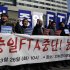 South Korean farmers shout slogans against the Free Trade Agreement between South Korea, Japan, and China during a rally denouncing the FTA talks in front of the venue where the discussions are being held, in Seoul, South Korea, Tuesday, March 26, 2013.  Negotiations for a Free Trade Agreement between the three countries will be held from March 26 - 28. The writing reads "Stop, FTA between South Korea, China and Japan." (AP Photo/Lee Jin-man)
