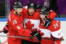 Canada forward Benn Jamie, center, celebrates his goal against the USA with teammates Jay Bouwmeester, left, and Corey Perry, right, during the second period of the men's semifinal ice hockey game at the 2014 Winter Olympics, Friday, Feb. 21, 2014, in Sochi, Russia. (AP Photo/Mark Humphrey)