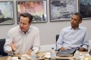 US President Barack Obama (R) listens as British PM David Cameron speaks at the G8 summit on June 18, 2013