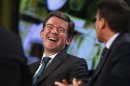 Britain's Minister for Sport laughs as chairman of the London organising committee of the Olympic Games answers a question during a Reuters Newsmaker event in London