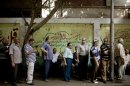 Egyptian men line up to vote at a polling station in the Shobra neighborhood of Cairo, Egypt on Sunday, June 17, 2012. Egyptians are choosing on Sunday between a conservative Islamist and Hosni Mubarak's ex-prime minister in the second day of a presidential runoff that has been overshadowed by questions on whether the ruling military will transfer power to civilian authority by July 1 as promised. (AP Photo/Pete Muller)