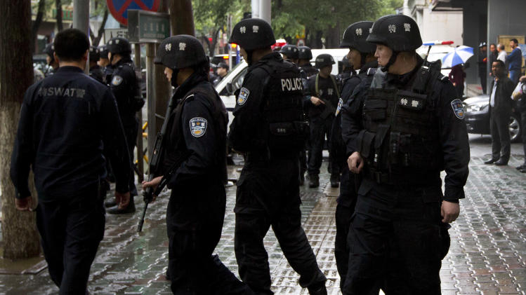 In this May 22, 2014 photo, armed policemen prepare to patrol near the site of the explosion in Urumqi, northwest China&#39;s Xinjiang Uygur Autonomous Region. So far this month, police in China&#39;s restive western region of Xinjiang have broken up 23 terror and religious extremism groups and caught over 200 suspects, state media reported Monday, May 26. (AP Photo/Andy Wong)