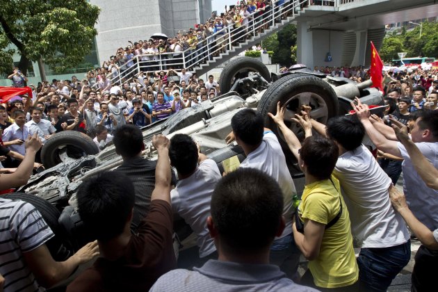 Protesters overturn a Japanese-brand police car during an anti-Japan protest in Shenzhen